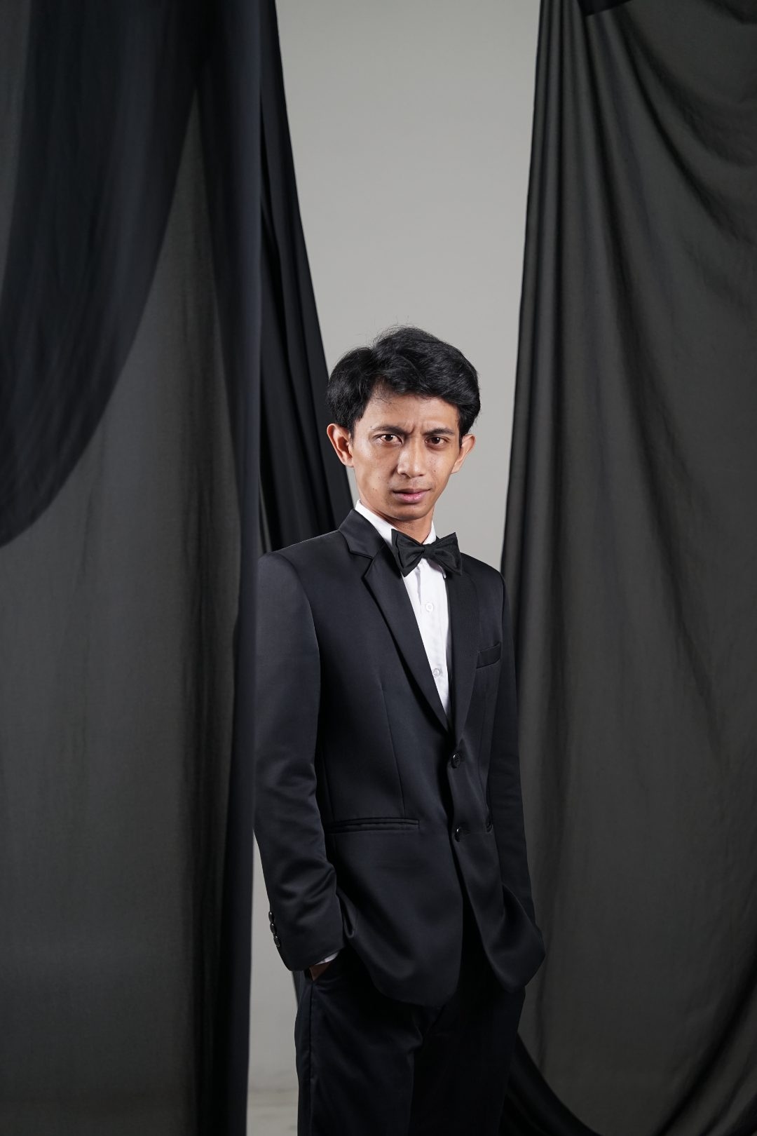 Potret Aditya Arya Megananda mengenakan tuksedo hitam